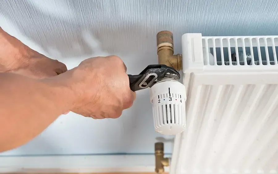 Réglage d'un robinet de radiateur lors d'une rénovation de chauffage à Poissy